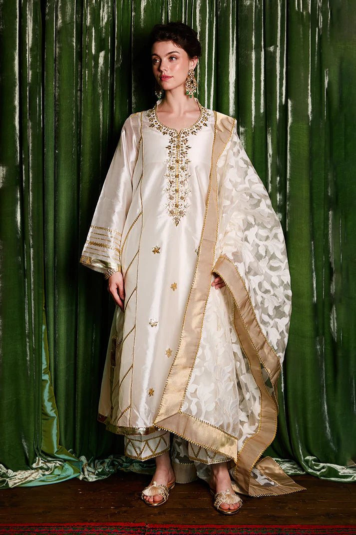 Model wearing a luxurious ivory and gold Moti dress from Mushq with elegant gota detailing, perfect for Pakistani weddings, available online in the UK.