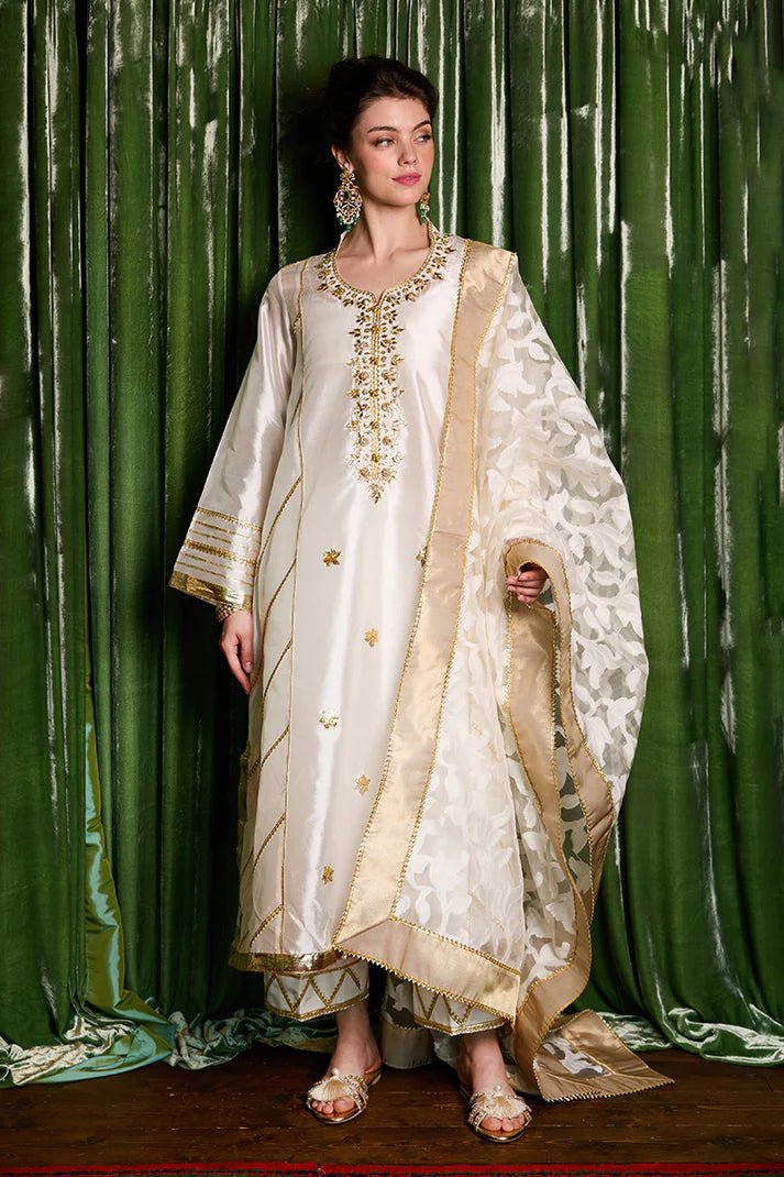 Model wearing a luxurious ivory and gold Moti dress from Mushq with elegant gota detailing, perfect for Pakistani weddings, available online in the UK.