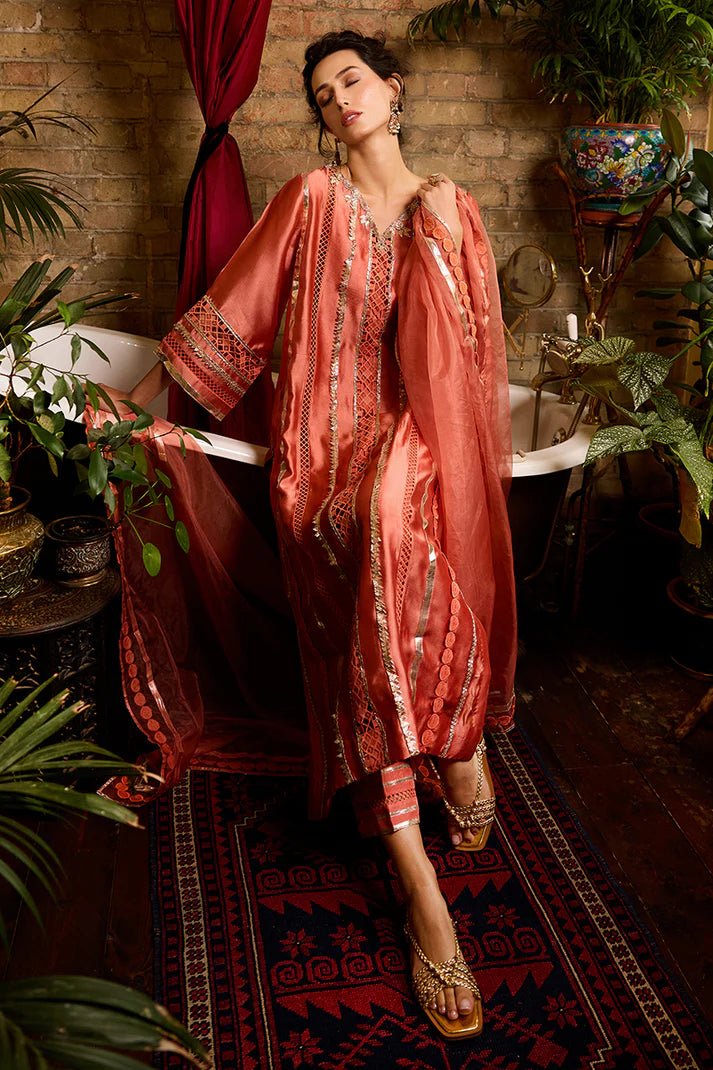 Model wearing a vibrant orange Rajputani Rani outfit from Mushq with intricate gota work, ideal for Pakistani weddings, available online in the UK.