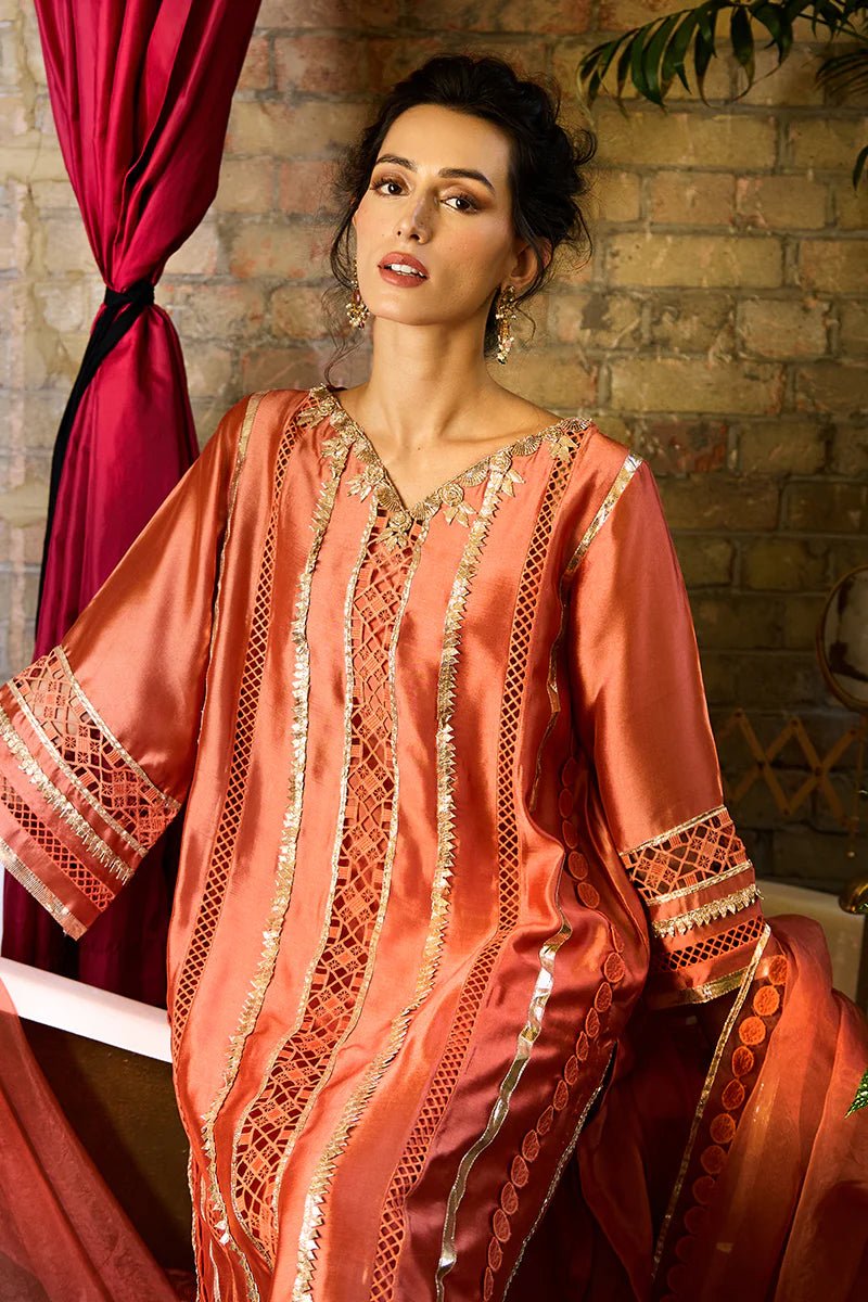 Model wearing a vibrant orange Rajputani Rani outfit from Mushq with intricate gota work, ideal for Pakistani weddings, available online in the UK.