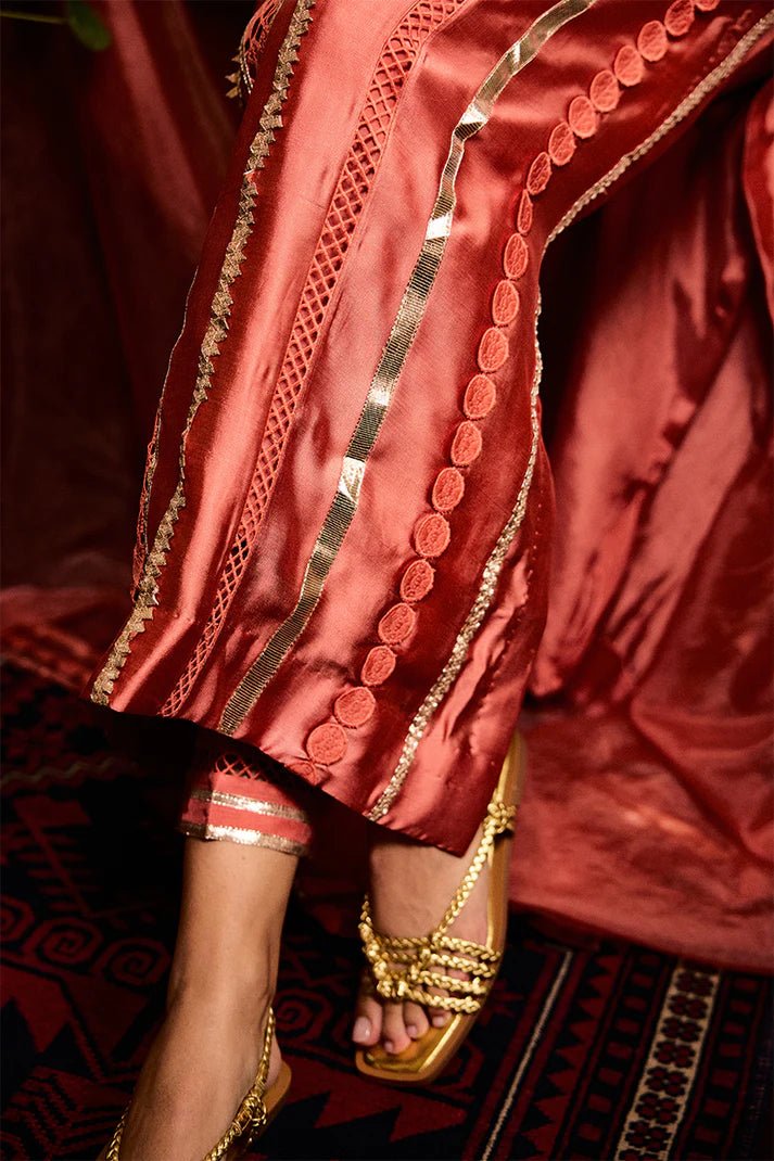 Model wearing a vibrant orange Rajputani Rani outfit from Mushq with intricate gota work, ideal for Pakistani weddings, available online in the UK.