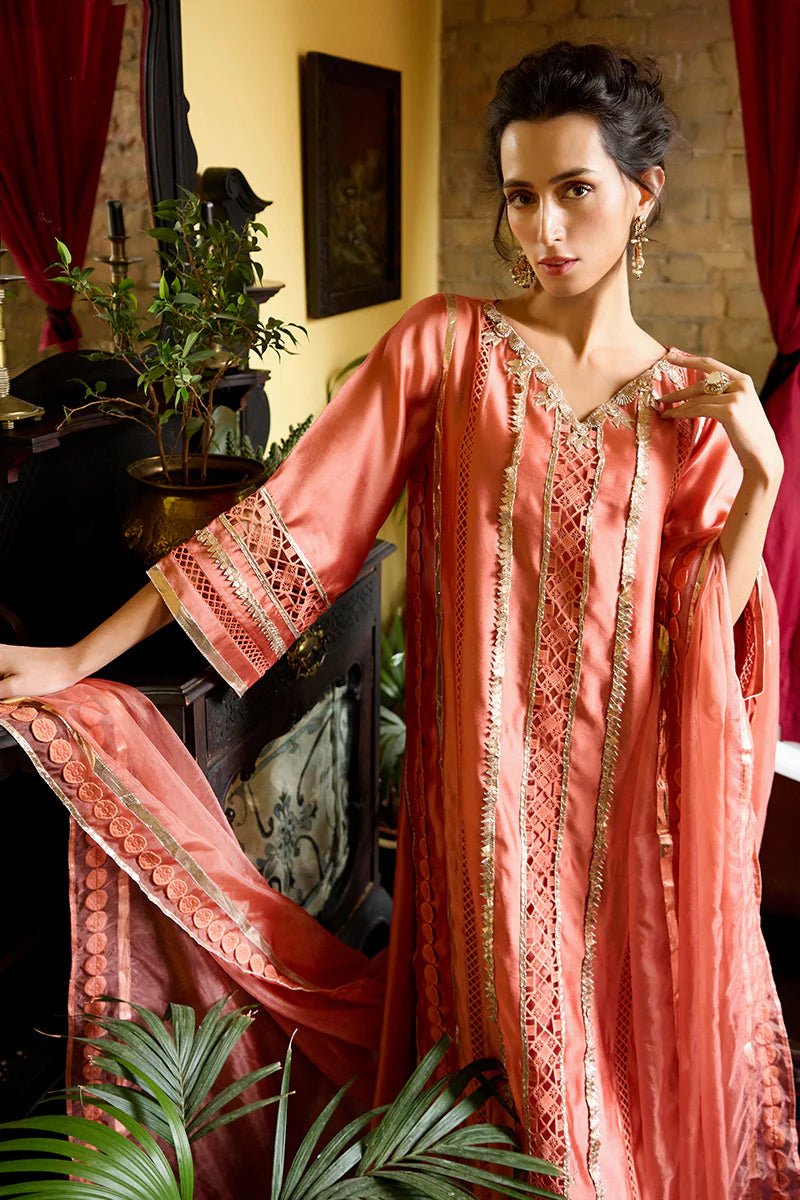 Model wearing a vibrant orange Rajputani Rani outfit from Mushq with intricate gota work, ideal for Pakistani weddings, available online in the UK.