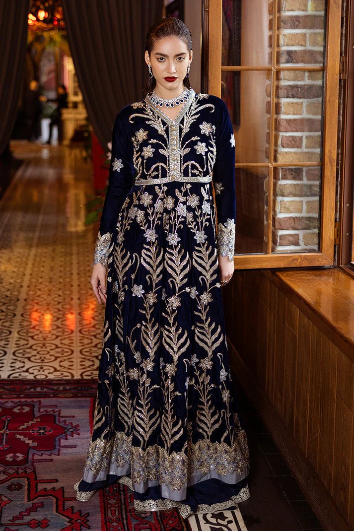 Model wearing Mushq DEJA VU - VELVET '24 Timeless Mirage, a rich navy velvet gown with intricate gold embroidery and silver accents, paired with a luxurious silver shawl. Perfect for winter weddings, available for Pakistani clothes online in the UK.