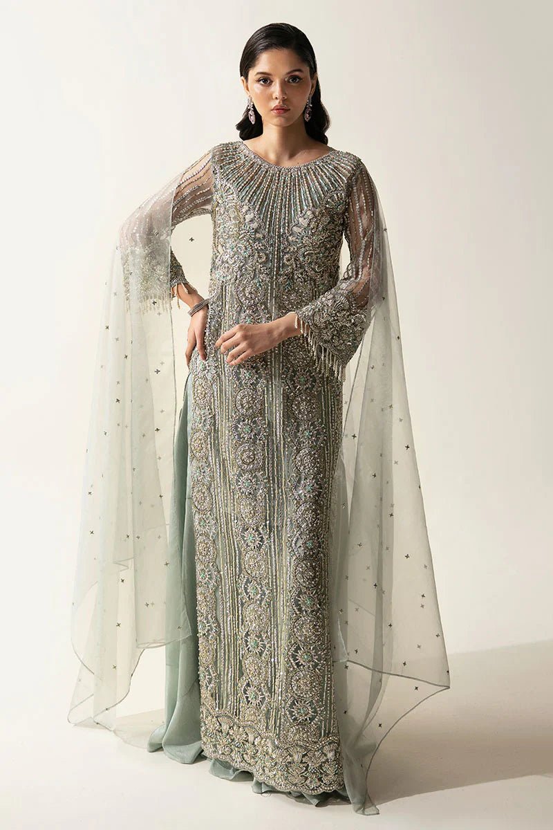 Model wearing Mushq's Meline dress from the Fluer Luxury Eid Pret collection, featuring intricate silver embellishments and a flowing silhouette, highlighting elegant Pakistani designer wear in the UK.