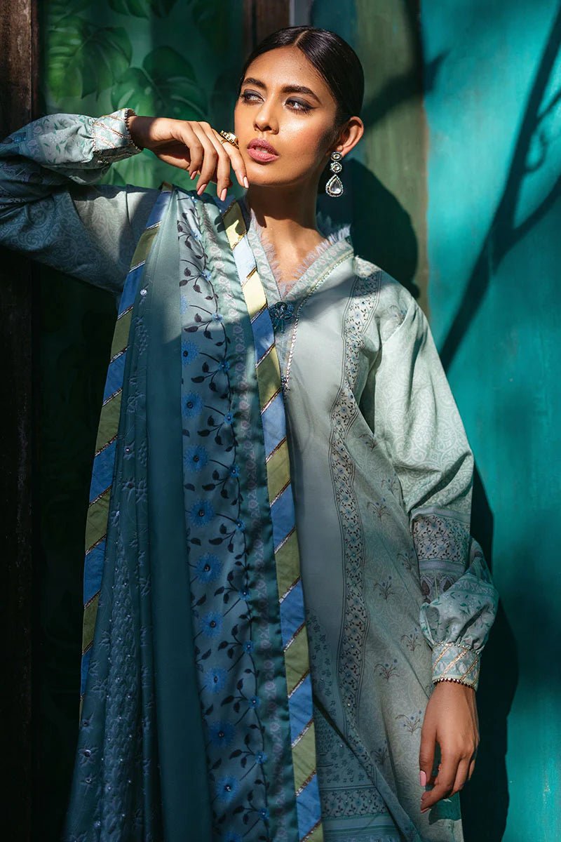 Model wearing Cerulean dress from Mushq's Nirvana Silk Edit, featuring elegant prints in shades of light blue and mint green. Pakistani winter casual pret clothes available online in the UK.