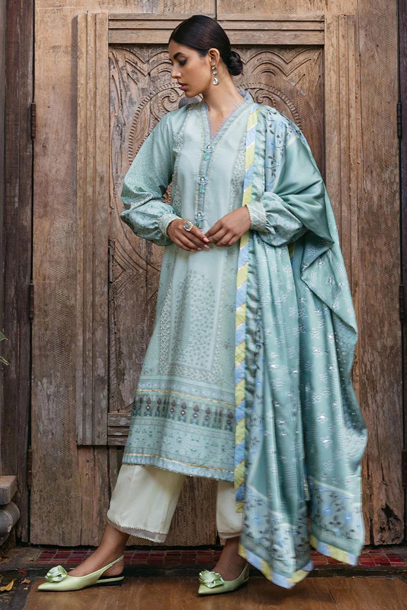 Model wearing Cerulean dress from Mushq's Nirvana Silk Edit, featuring elegant prints in shades of light blue and mint green. Pakistani winter casual pret clothes available online in the UK.