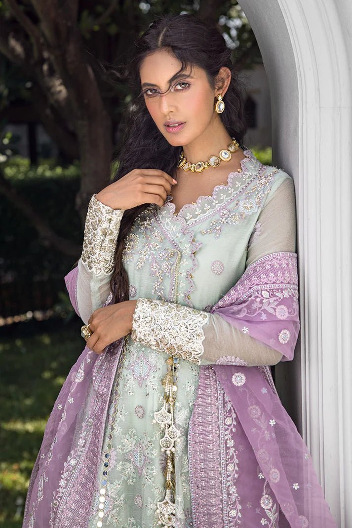 Model wearing a green dress with intricate embroidery from Mushq's Roohi Luxury Collection. Ideal for Pakistani wedding clothes online in UK.