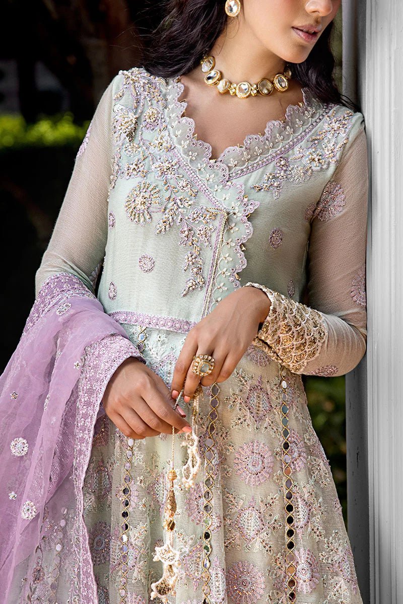 Model wearing a green dress with intricate embroidery from Mushq's Roohi Luxury Collection. Ideal for Pakistani wedding clothes online in UK.