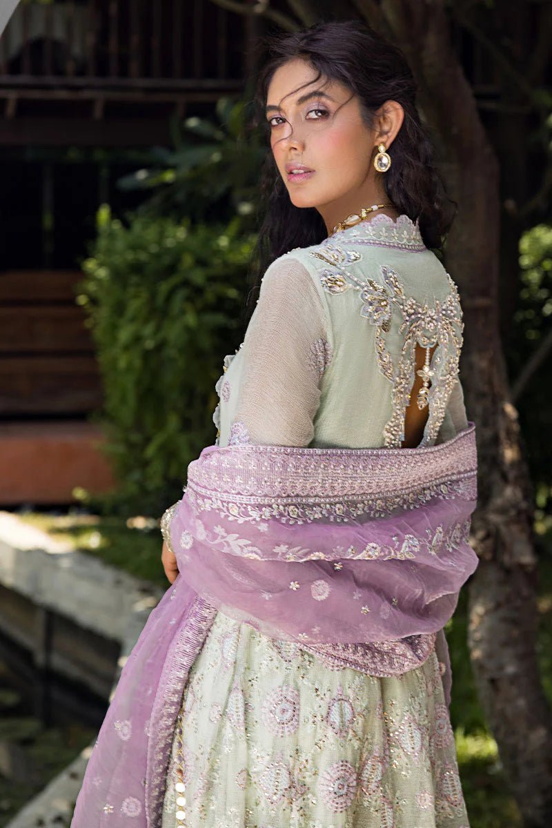 Model wearing a green dress with intricate embroidery from Mushq's Roohi Luxury Collection. Ideal for Pakistani wedding clothes online in UK.