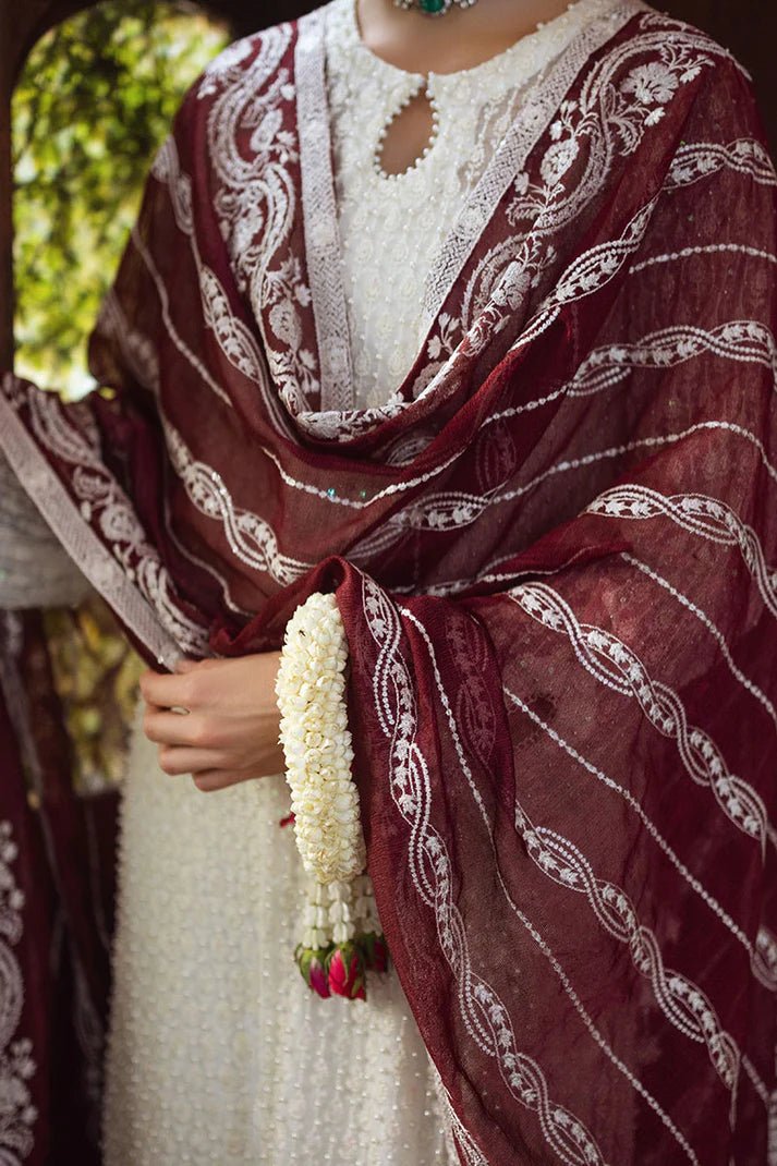 Model wearing white ROYA dress with maroon shawl from Mushq, Saugaat Chickenkari Pret collection. Pakistani designer clothes in UK, readymade clothes, elegant and stylish.