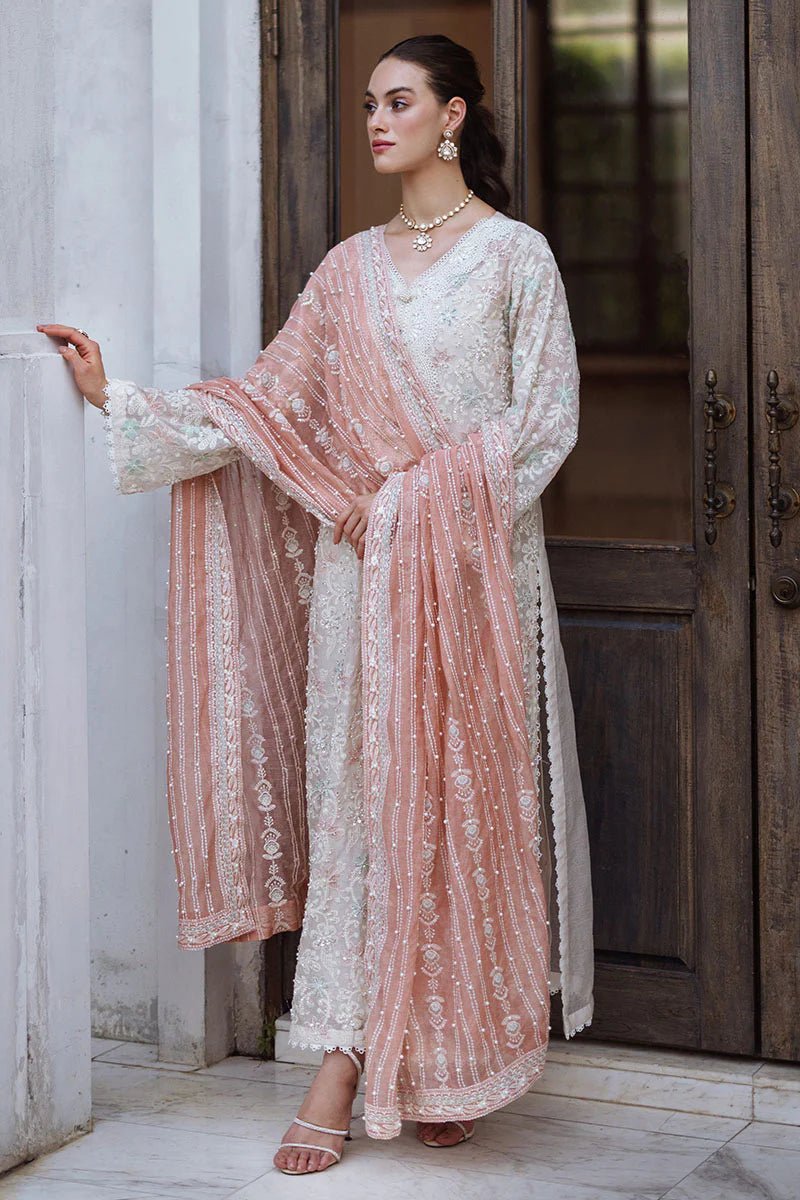 Model wearing a pastel pink and white ZIBA dress from Mushq, Saugaat Chickenkari Pret collection. Pakistani designer clothes in UK, readymade clothes, elegant and stylish.