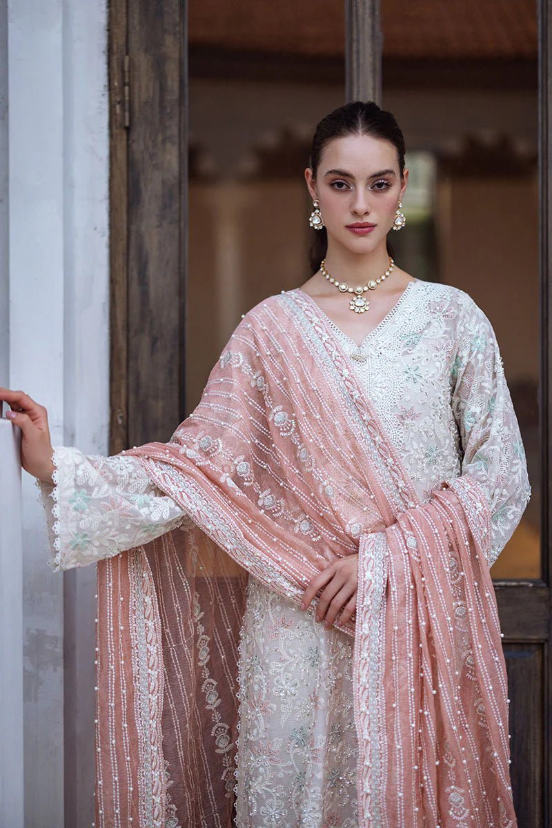 Model wearing a pastel pink and white ZIBA dress from Mushq, Saugaat Chickenkari Pret collection. Pakistani designer clothes in UK, readymade clothes, elegant and stylish.