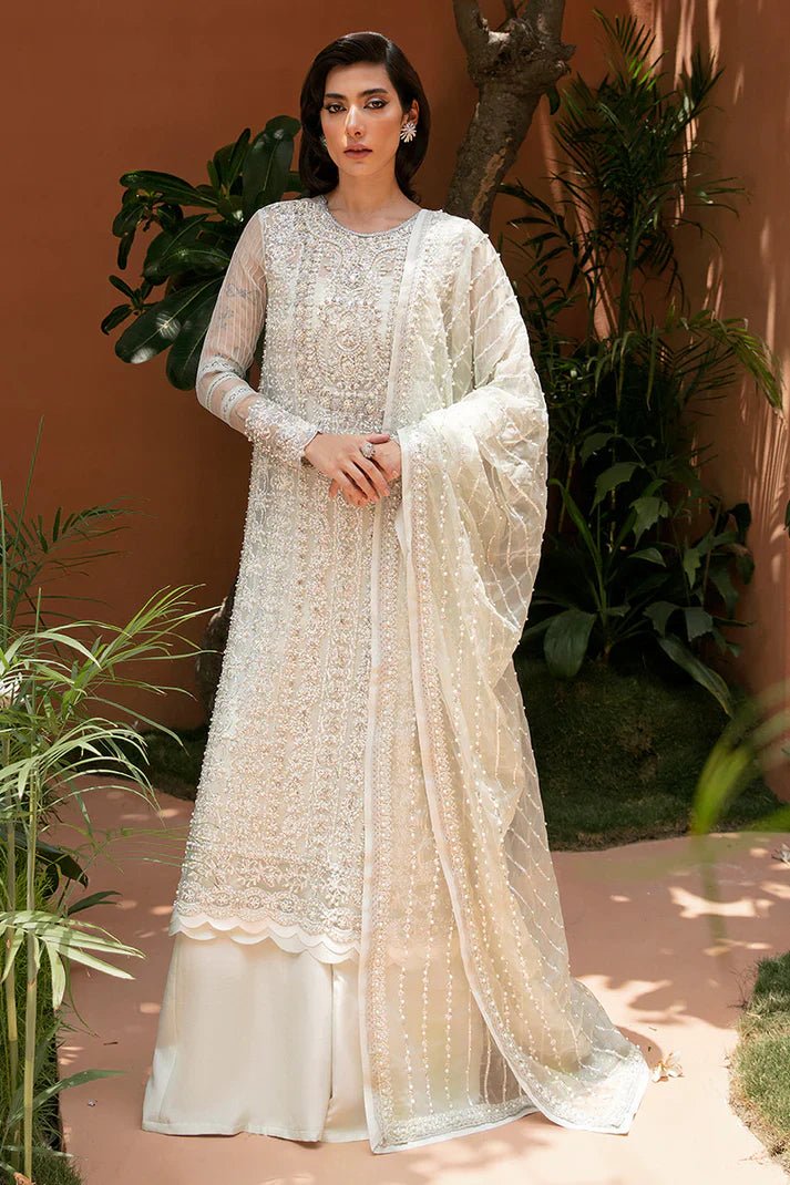 Model wearing Mushq's Chiara dress in ivory, highlighting Pakistani wedding clothes in the UK.