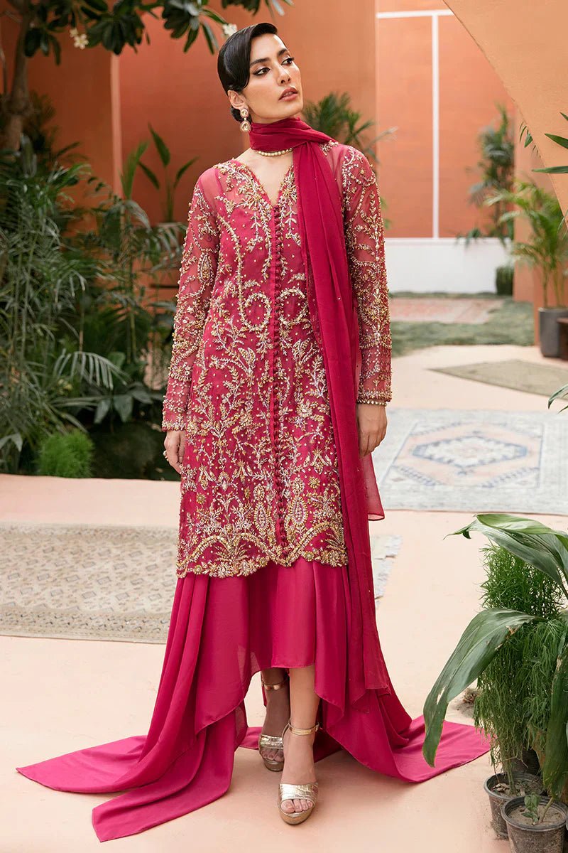 Model wearing Mushq's Rosalia dress in deep pink with golden embroidery, perfect for weddings and showcasing Pakistani designer clothes in the UK.