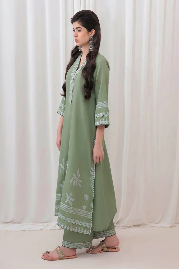 Model wearing Mushq Wisteria Winter Basic Pret '24 Alpine Aura, a sage green dress with floral embroidery, ideal for winter casual wear. Available for Pakistani clothes online in the UK.