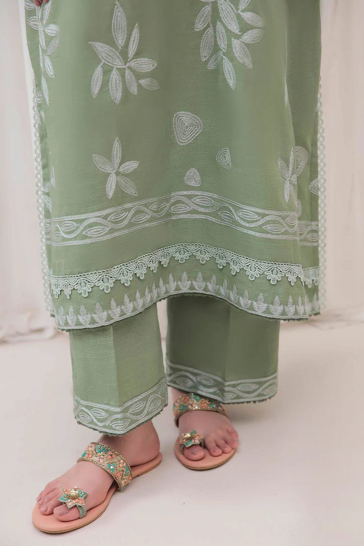 Model wearing Mushq Wisteria Winter Basic Pret '24 Alpine Aura, a sage green dress with floral embroidery, ideal for winter casual wear. Available for Pakistani clothes online in the UK.