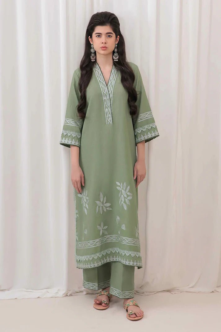 Model wearing Mushq Wisteria Winter Basic Pret '24 Alpine Aura, a sage green dress with floral embroidery, ideal for winter casual wear. Available for Pakistani clothes online in the UK.