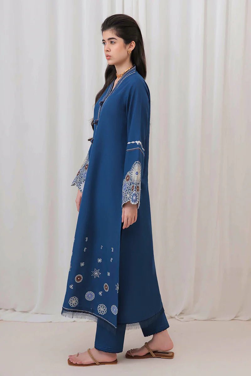 Model wearing Mushq Wisteria Winter Basic Pret '24 Arctic Allure, a deep blue dress with intricate patterns, perfect for winter casual wear. Available for Pakistani clothes online in the UK.