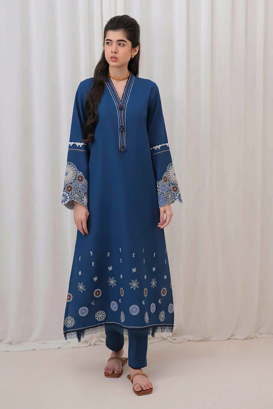 Model wearing Mushq Wisteria Winter Basic Pret '24 Arctic Allure, a deep blue dress with intricate patterns, perfect for winter casual wear. Available for Pakistani clothes online in the UK.