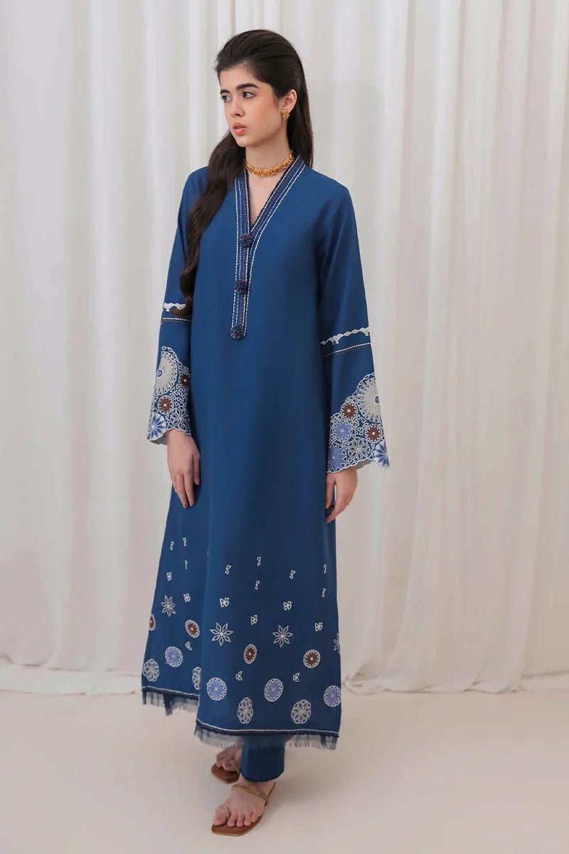 Model wearing Mushq Wisteria Winter Basic Pret '24 Arctic Allure, a deep blue dress with intricate patterns, perfect for winter casual wear. Available for Pakistani clothes online in the UK.