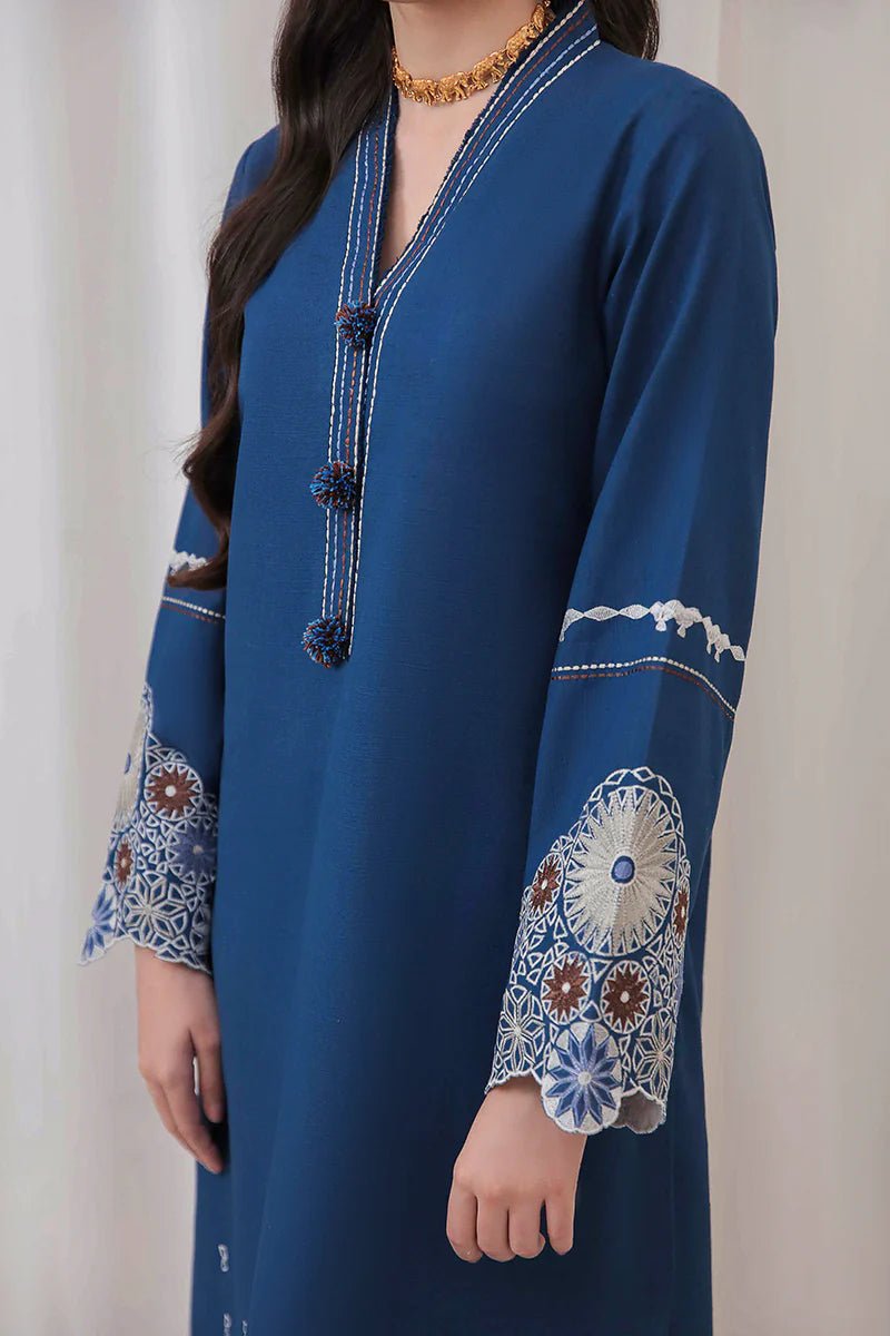 Model wearing Mushq Wisteria Winter Basic Pret '24 Arctic Allure, a deep blue dress with intricate patterns, perfect for winter casual wear. Available for Pakistani clothes online in the UK.