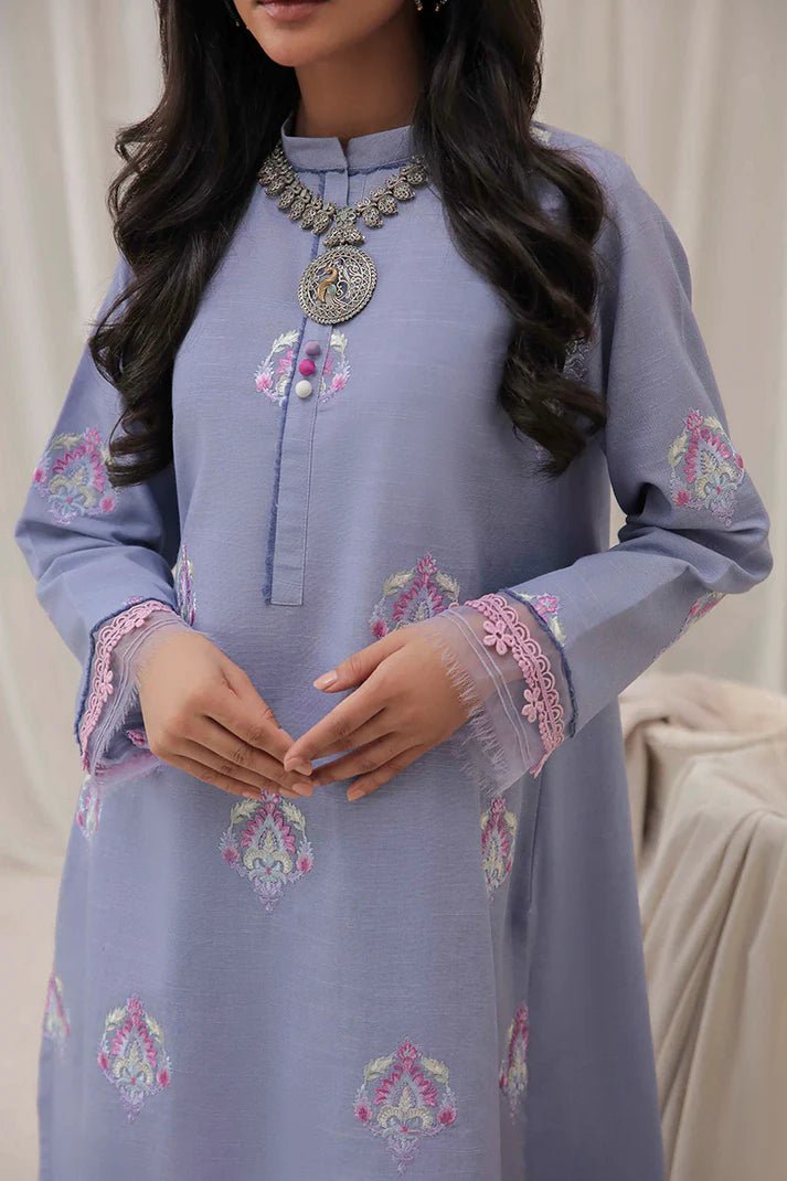 Model wearing Mushq Wisteria Winter Basic Pret '24 Crystal Frost, a light blue dress with delicate embroidery, ideal for winter casual wear. Available for Pakistani clothes online in the UK.