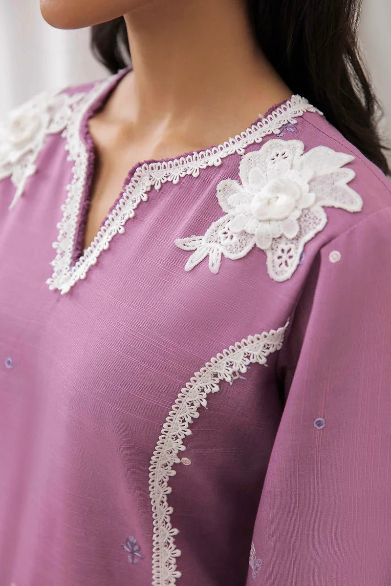 Model wearing Mushq Wisteria Winter Basic Pret '24 Frost Flair, a lavender dress adorned with white lace details, perfect for winter casual wear. Available for Pakistani clothes online in the UK.