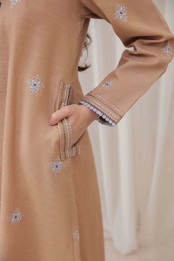 Model wearing Mushq Wisteria Winter Basic Pret '24 Frost Kissed, a beige dress with subtle blue embroidery, ideal for winter casual wear. Available for Pakistani clothes online in the UK.