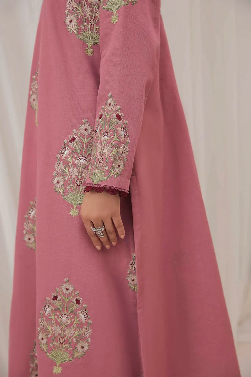 Model wearing Mushq Wisteria Winter Basic Pret '24 Polar Vogue, a rose pink dress with intricate embroidery, ideal for winter casual wear. Available for Pakistani clothes online in the UK.