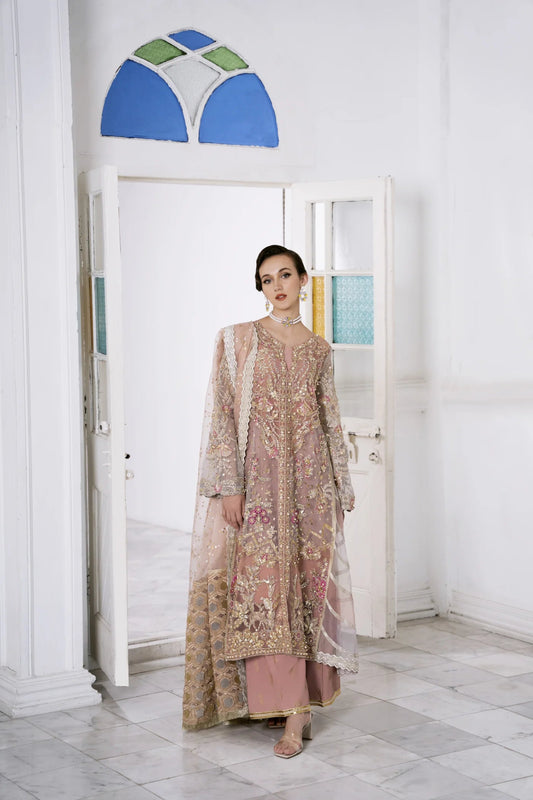 Model wearing a pastel pink LUBNA dress with intricate embroidery and embellishments, from Mysie by Tahira. Find Pakistani clothes online in UK, perfect for weddings.