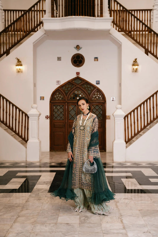 Model wearing a teal and gold RAVEENA dress from Mysie by Tahira, featuring intricate embroidery and a full - length design. Perfect for weddings and special occasions.