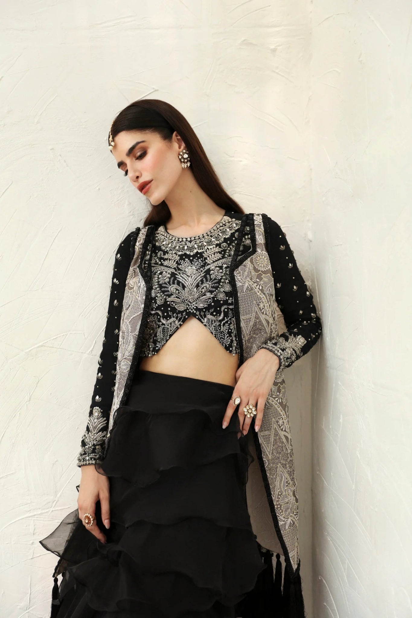 Model wearing Alayna from Mysie by Tahira in a black embellished crop top with long sleeves and tiered ruffled skirt. Pakistani wedding clothes online in UK.