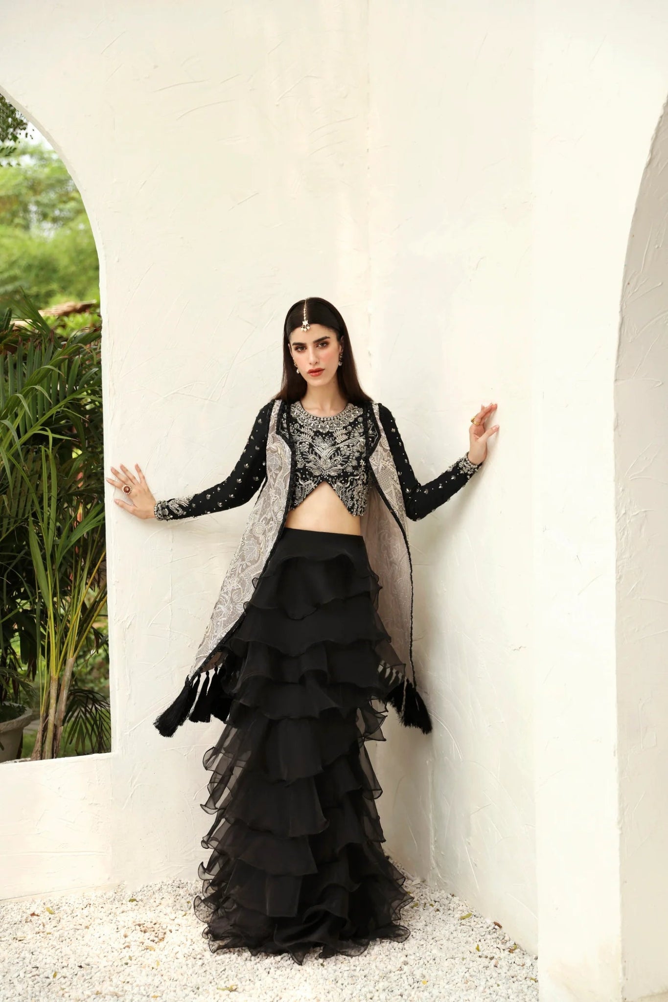 Model wearing Alayna from Mysie by Tahira in a black embellished crop top with long sleeves and tiered ruffled skirt. Pakistani wedding clothes online in UK.