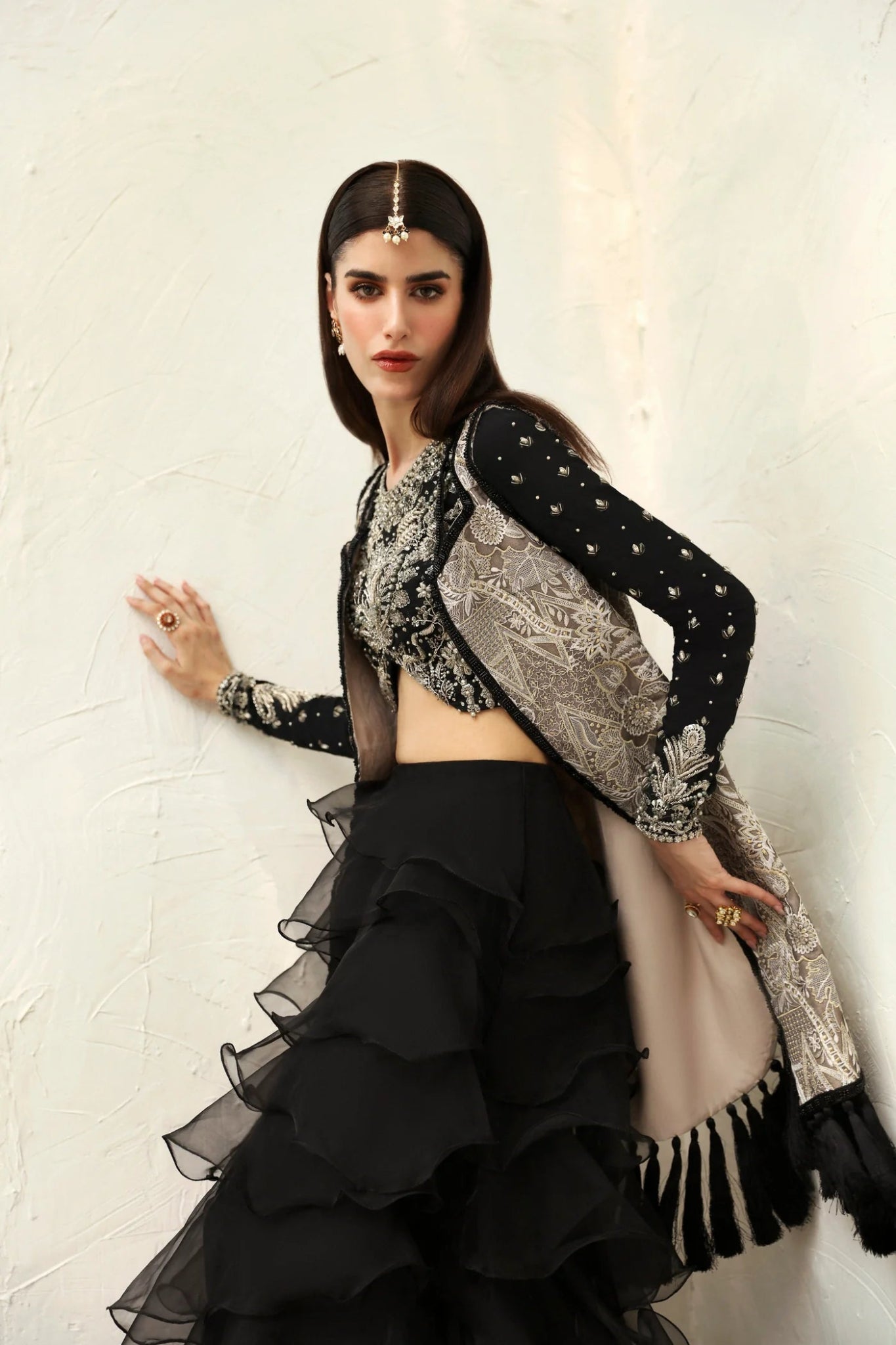 Model wearing Alayna from Mysie by Tahira in a black embellished crop top with long sleeves and tiered ruffled skirt. Pakistani wedding clothes online in UK.