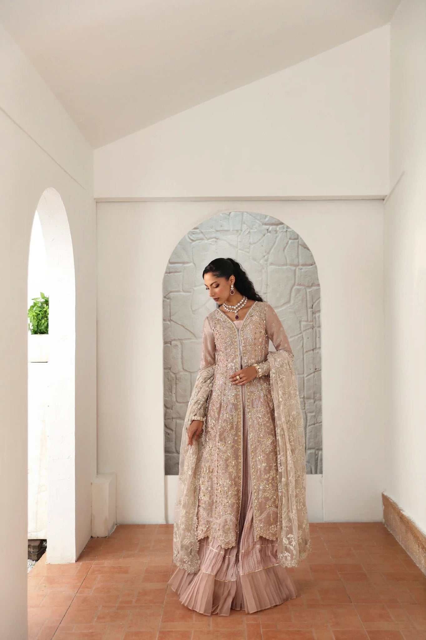 Model wearing Yara from Mysie by Tahira in a blush pink heavily embellished formal dress with pleated lehenga. Pakistani wedding clothes online in UK.