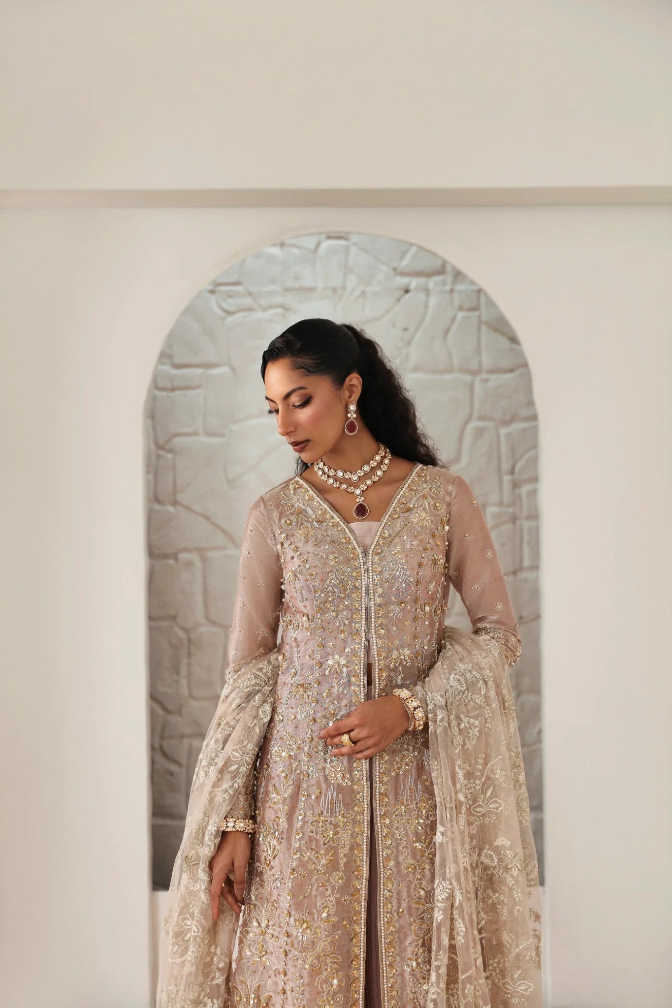 Model wearing Yara from Mysie by Tahira in a blush pink heavily embellished formal dress with pleated lehenga. Pakistani wedding clothes online in UK.