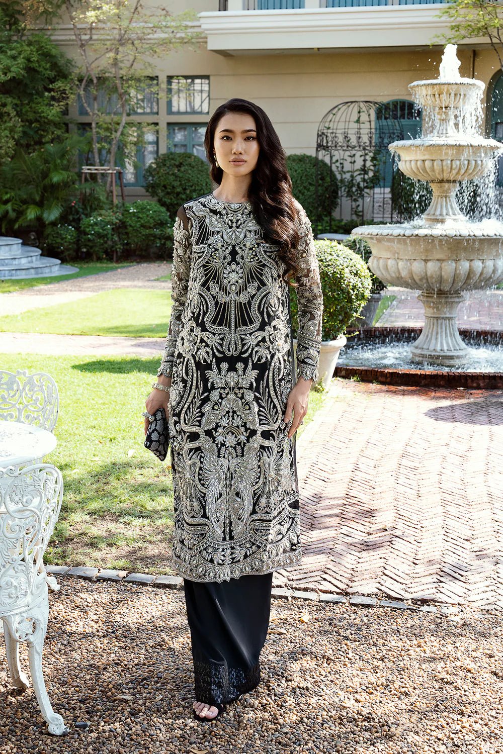 Model in black Daisy dress from Mysie by Tahira Eid Pret '24, epitomizing elegant Pakistani attire in the UK.