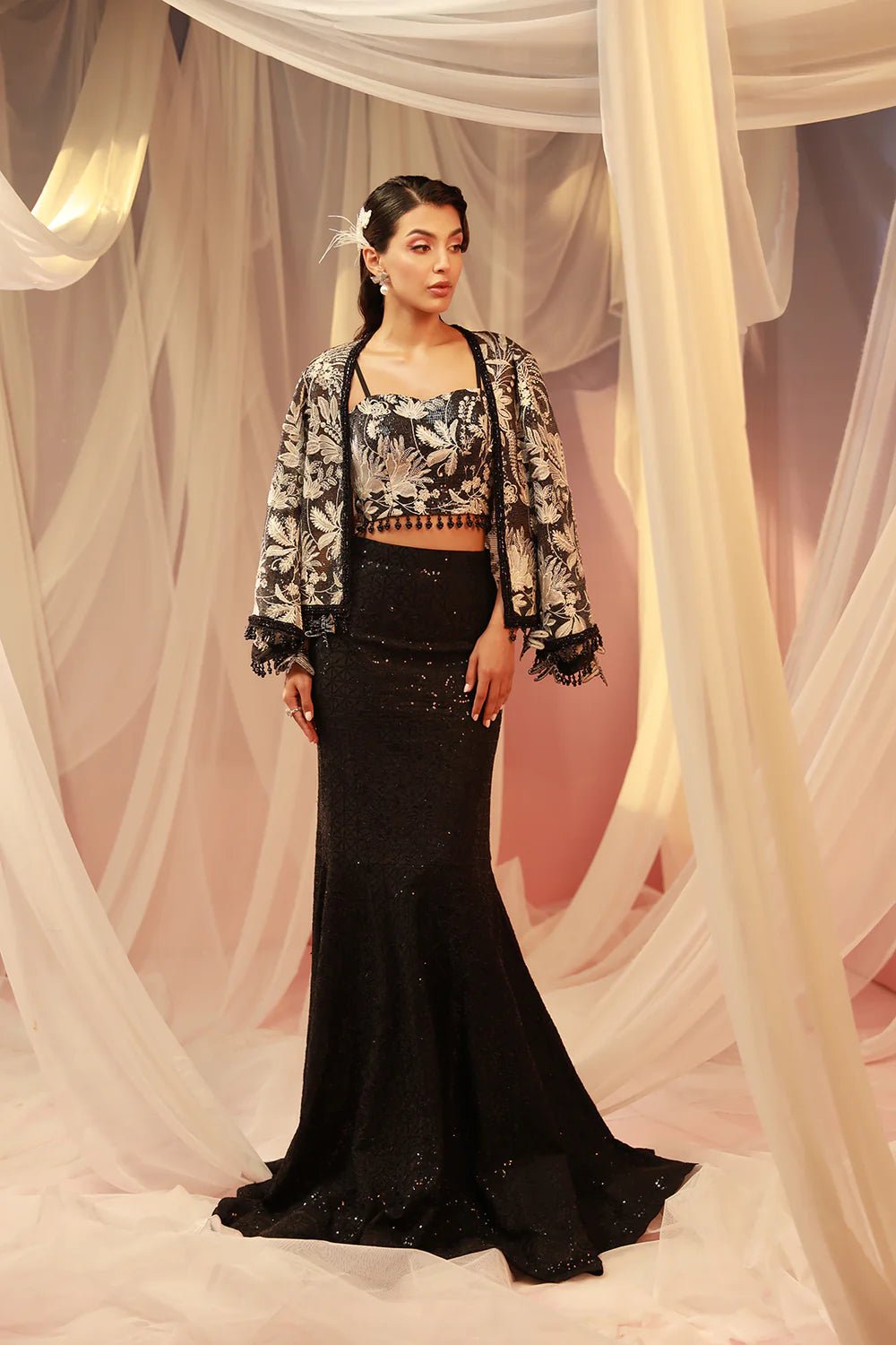 Model in black Rai dress from Mysie by Tahira Eid Pret '24, reflecting the allure of Pakistani evening wear in the UK.