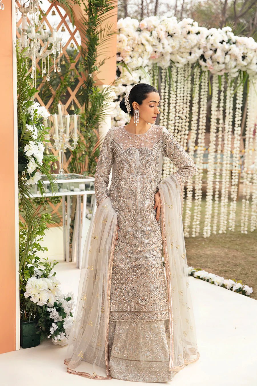 Model in Mysie By Tahira's Abiha dress, an exquisite silver bridal ensemble, epitomizing Pakistani clothes in the UK.