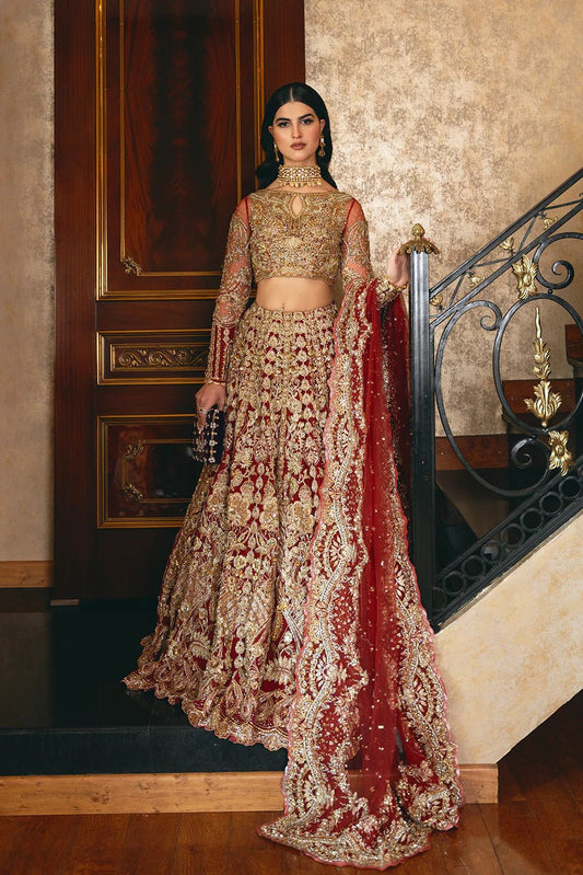 Model in Mysie By Tahira Nishwa dress, regal red lehenga, showcasing luxurious Pakistani clothes UK.