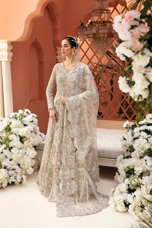 Model in a silver Mysie By Tahira Rylee bridal gown amidst flowers, showcasing exquisite Pakistani clothes UK.
