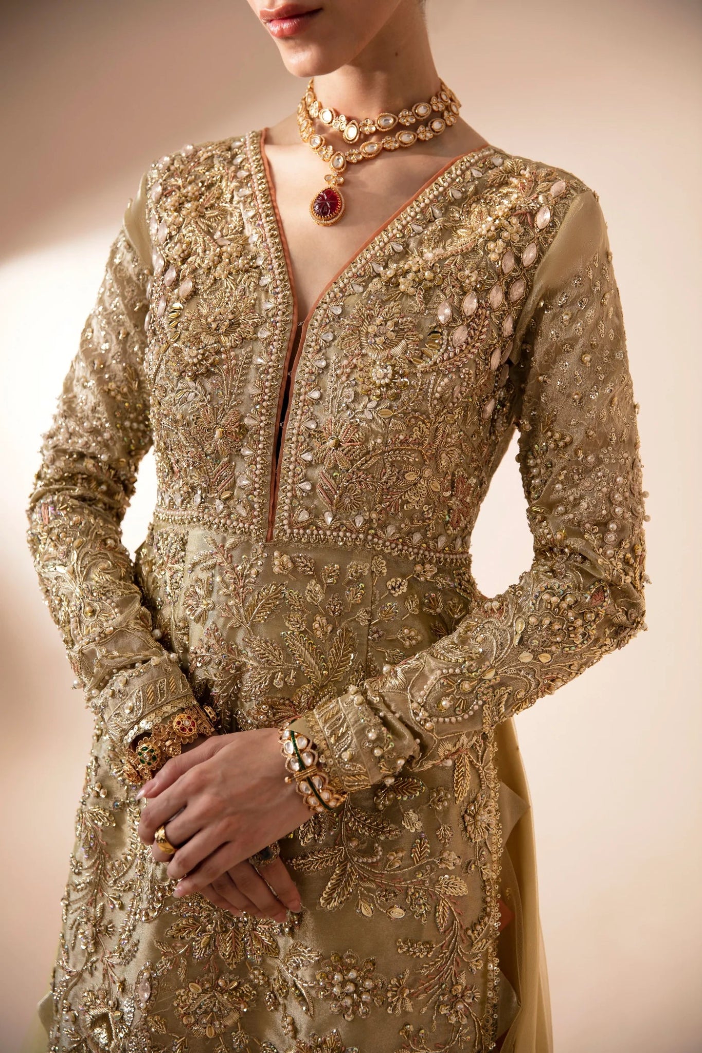 Model wearing Aram from Mysie by Tahira in a gold embellished bridal dress with a peach dupatta. Pakistani wedding clothes online in UK.