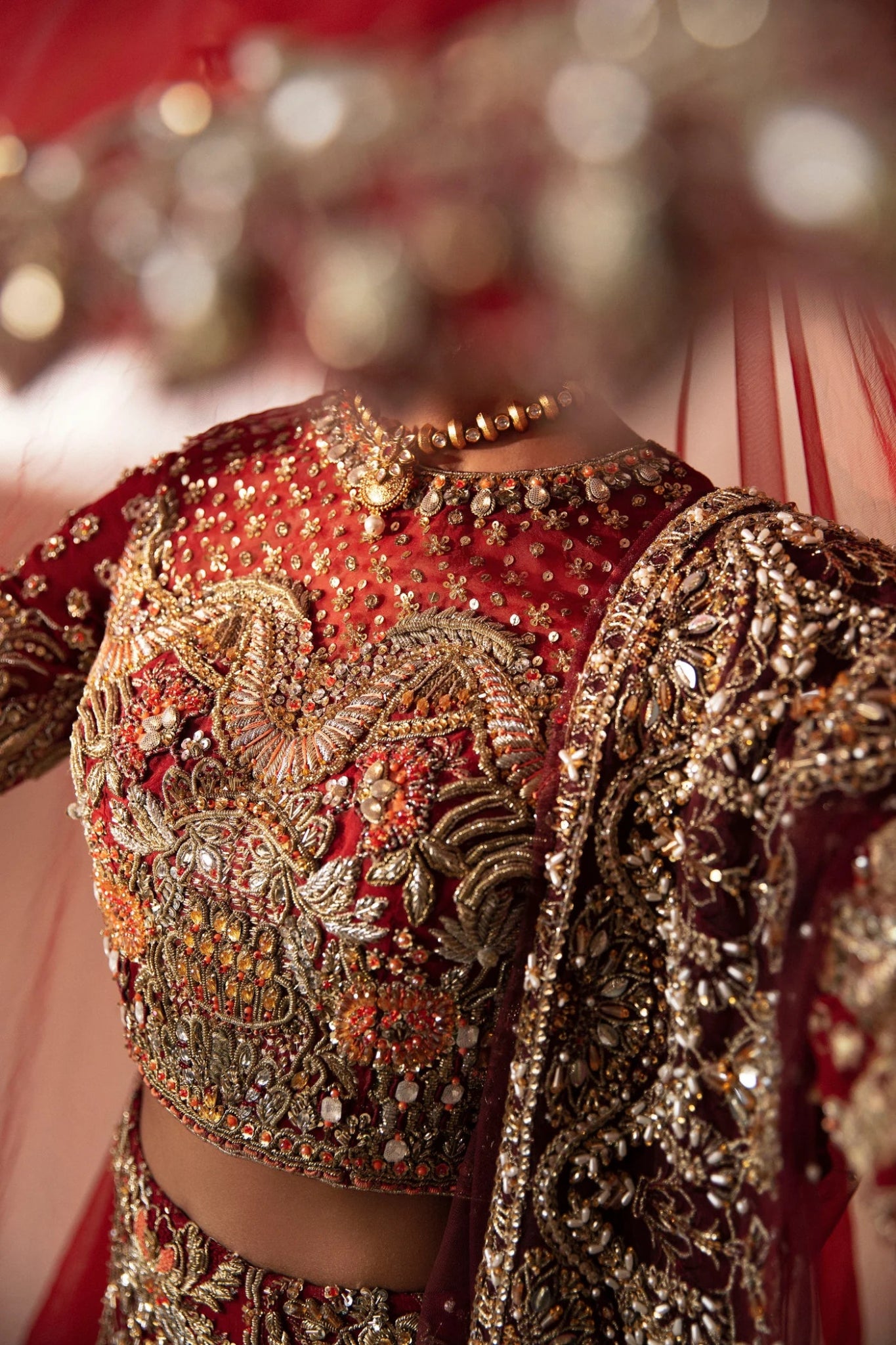 Model wearing Leela from Mysie by Tahira in a red and gold heavily embellished bridal lehenga. Pakistani wedding clothes online in UK.