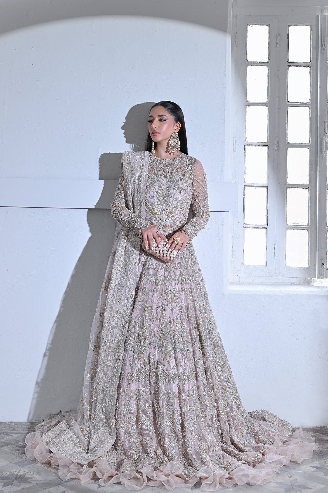 Model wearing Mysie by Tahira Poetique Bridals AFRIN, a pastel pink heavily embellished bridal dress, ideal for weddings. Available as Pakistani clothes online in the UK.