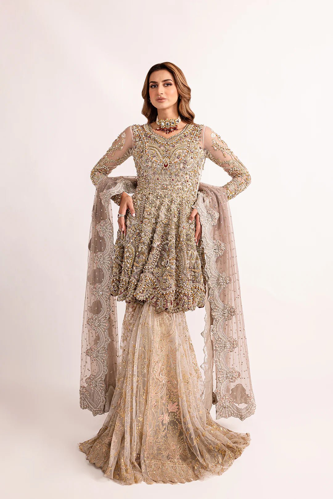 Model wearing Mysie by Tahira's Gulbano dress from the Zahra Luxury Pret '24 collection. A stunning silver Pakistani wedding outfit richly embellished with gold, perfect for those seeking Pakistani designer wedding clothes in the UK.