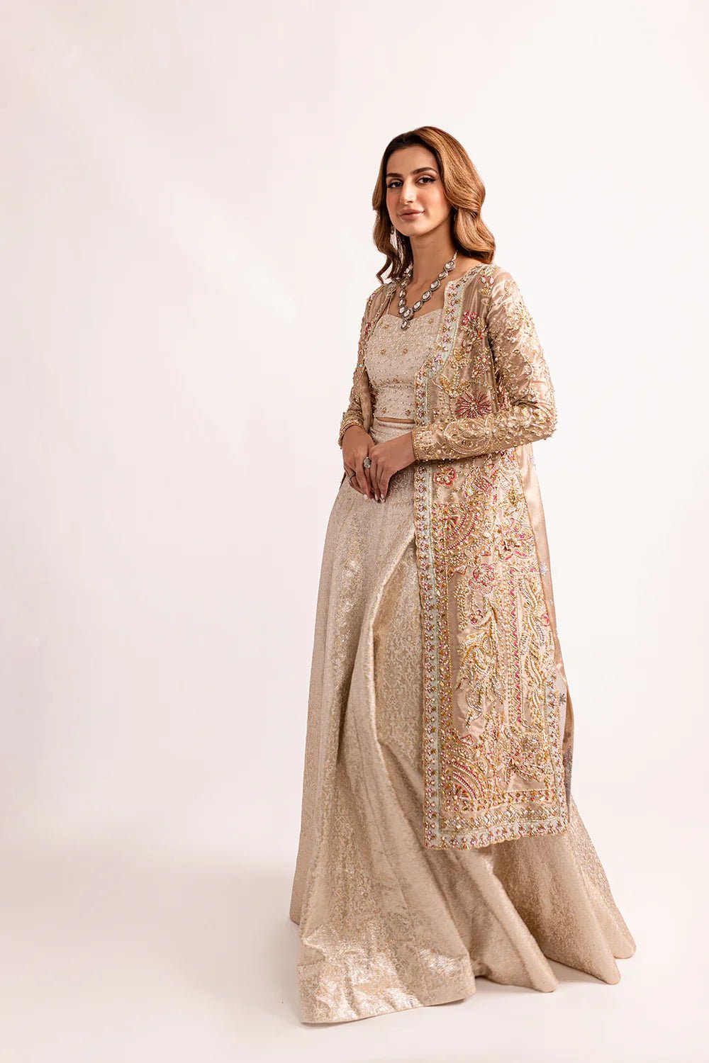 Model wearing Mysie by Tahira's Huma dress from the Zahra Luxury Pret '24 collection. A lavish gold Pakistani wedding outfit with intricate multicolored embroidery, perfect for those seeking Pakistani designer wedding clothes in the UK.