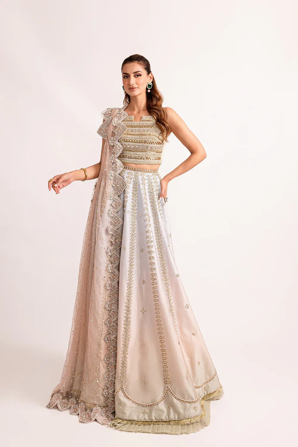 Model wearing Mysie by Tahira's Kubra dress from the Zahra Luxury Pret '24 collection. An elegant off - white Pakistani wedding outfit with gold embellishments, perfect for those seeking Pakistani designer wedding clothes in the UK.