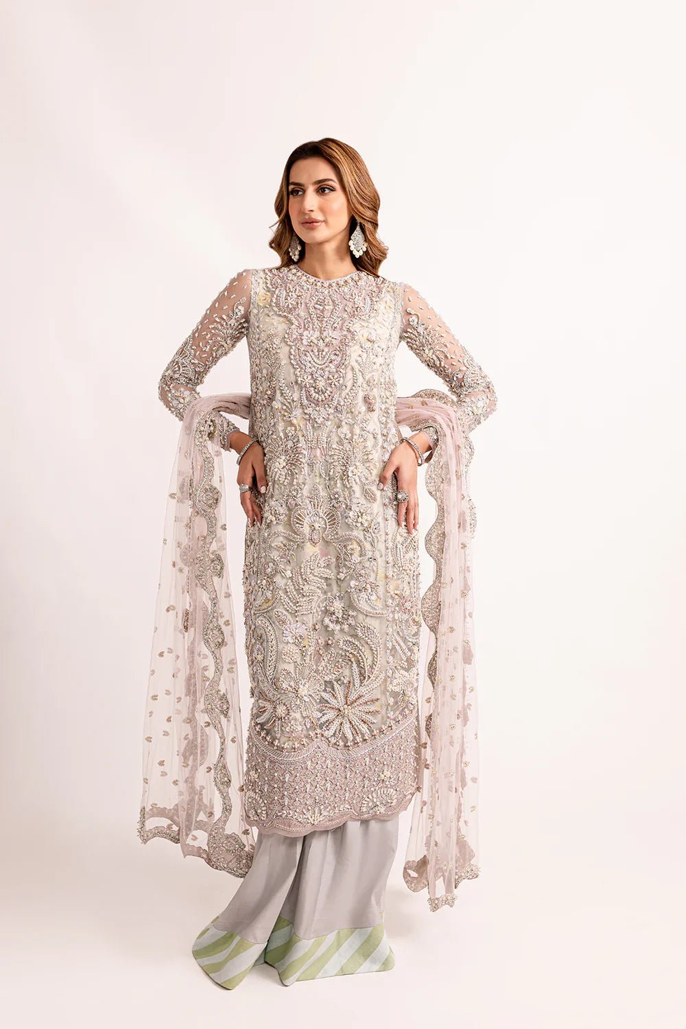 Model wearing Mysie by Tahira's Shebra dress from the Zahra Luxury Pret '24 collection. A luxurious silver Pakistani wedding outfit with exquisite embroidery, perfect for those seeking Pakistani designer wedding clothes in the UK.