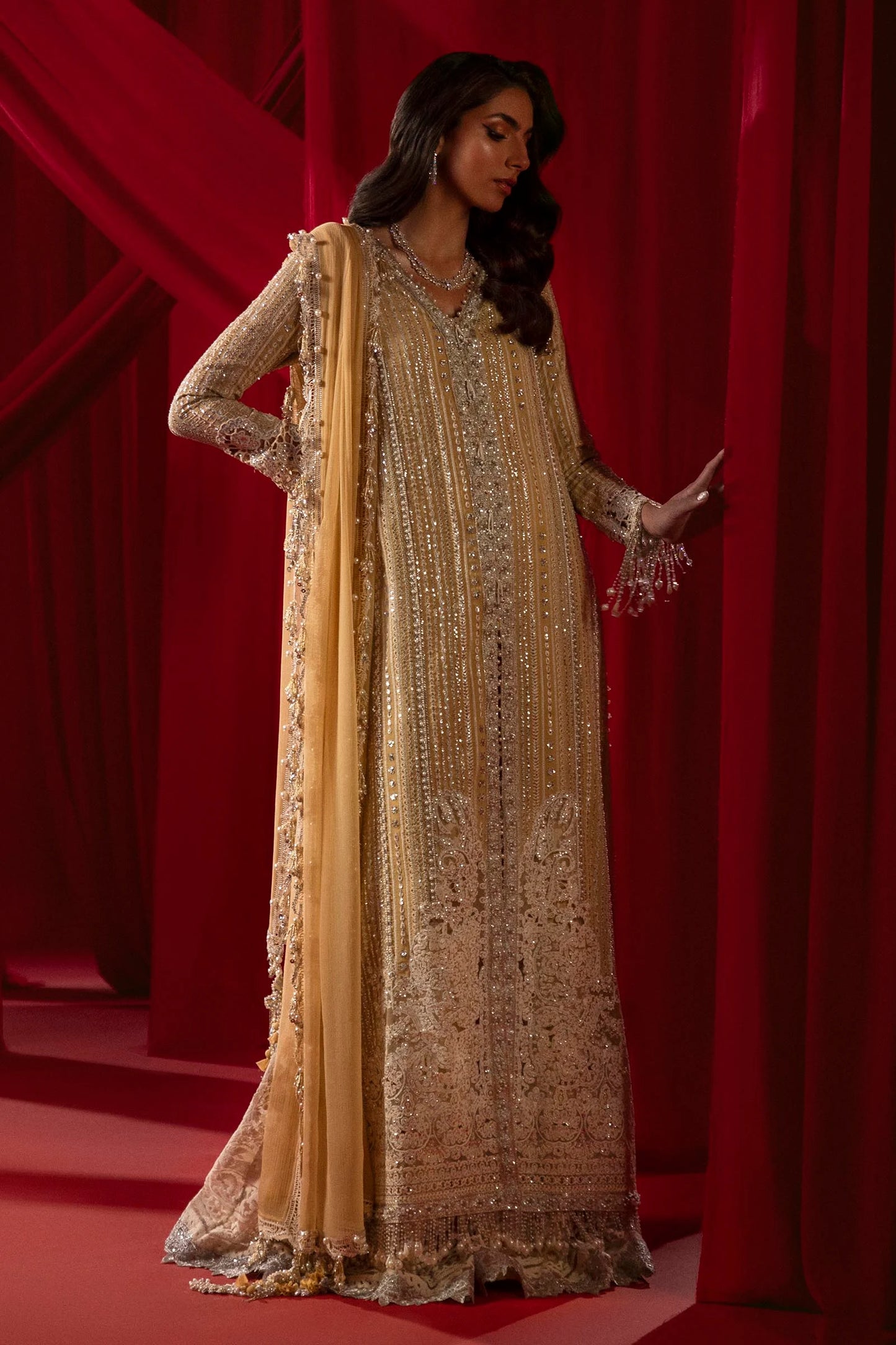 Model in Sana Safinaz gold NURA dress, highlighting luxury Pakistani attire for the UK market.