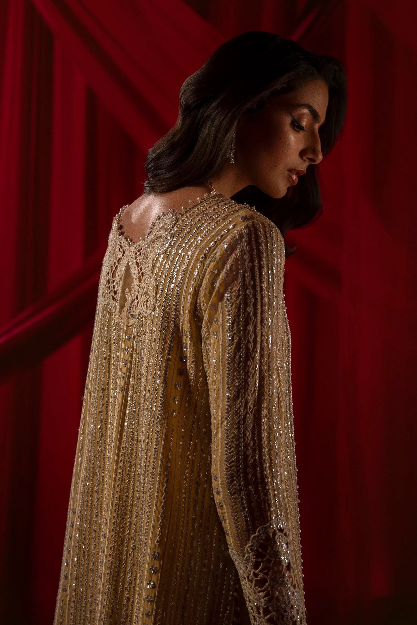 Model in Sana Safinaz gold NURA dress, highlighting luxury Pakistani attire for the UK market.